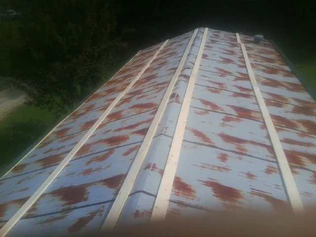 Rusted metal roof panels with new wood purlins before replacement — Storm Damage Roof Repair in Elmhurst by Roofing Brothers