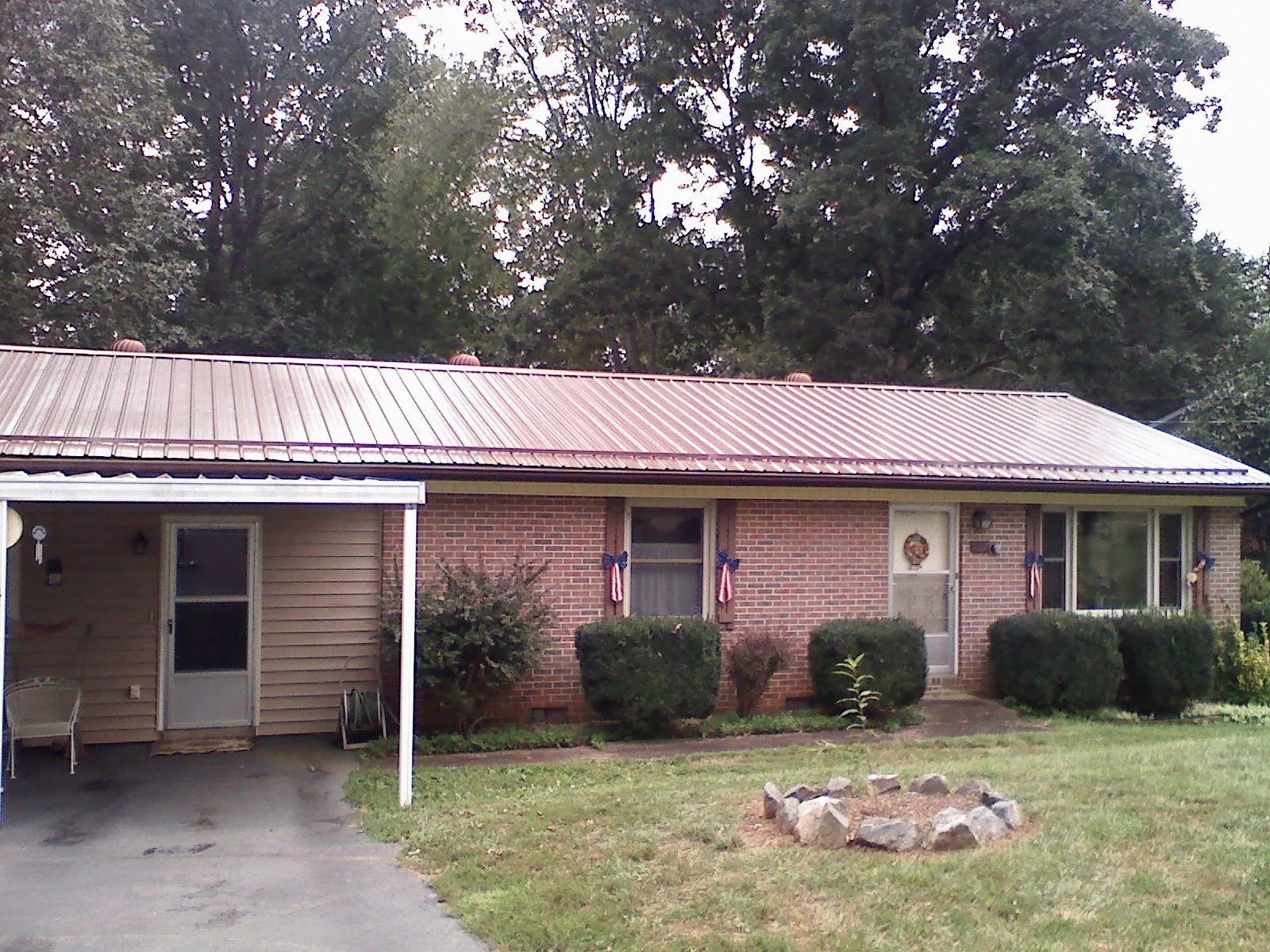 Bronze metal roof and carport on a brick ranch home — Roof Repair work by our crew in Elmhurst